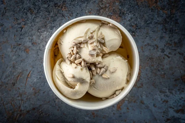 香草坚果冰淇淋球 种子在白纸杯灰色石头背景 — 图库照片