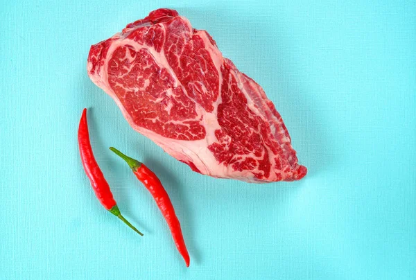 Heldere Rauwe Biefstuk Met Rode Chili Peper Een Blauwe Achtergrond — Stockfoto