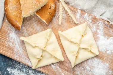 Tahta bir Khachapuri ulusal yemeğinin üzerinde peynirli pişmemiş turta.