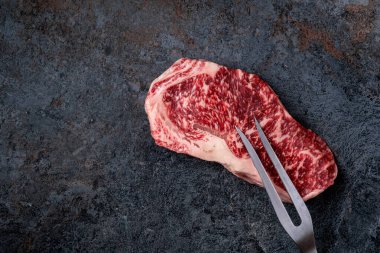 Çiğ Wagyu bifteği ve et çatalı. Japon mermer eti, üst manzara.