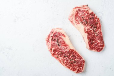 Taze mermer biftekler, tuzlu ve biberli ızgara için hazır, üst görünüm ve kopyalama alanı
