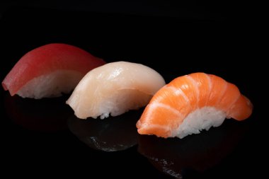 Siyah arka planda izole edilmiş çeşitli klasik nigiri suşi setleri.