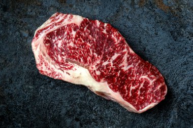 Taştan masada çiğ Wagyu bifteği. Japon mermer eti, üst manzara.