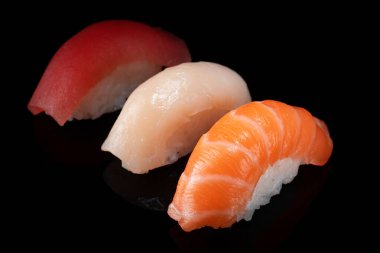 Siyah arka planda izole edilmiş çeşitli klasik nigiri suşi setleri.
