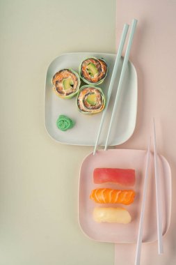 Bir tabak dolusu suşi nigiri ve salatalık ve somonlu dürüm, modern tarzda.