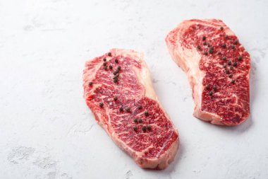 Beyaz taştan bir masada çiğ Striploin bifteği