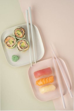 Bir tabak dolusu suşi nigiri ve salatalık ve somonlu dürüm, modern tarzda.