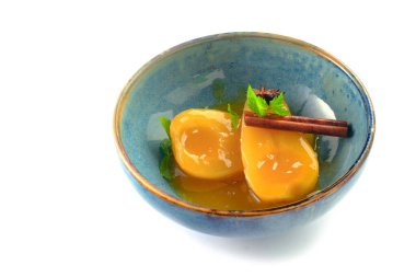 Baharatlı haşlanmış armut ve tarçın şurubu mavi kasede, tatlı tatlı.