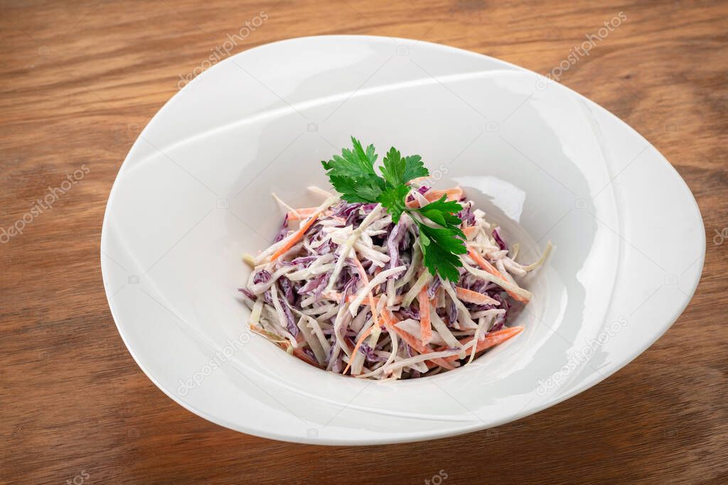 Red cabbage and carrot salad in a white plate, vegan healthy dish