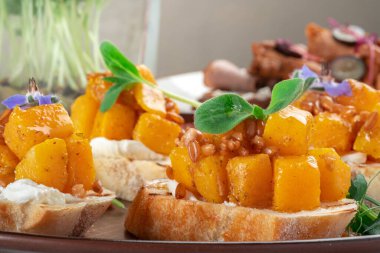 Vejetaryen aperatifi, kızarmış balkabağı, peynir ve incili arpa, yakın çekim.