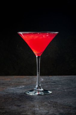 Koyu taşlı arka planda Cosmopolitan kokteyli, votka, kızılcık suyu ve vermutlu limon suyu karışımı.