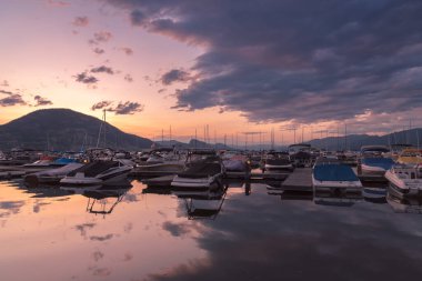 Penticton, British Columbia / Canada - 7 Temmuz 2020: Okanagan Gölü 'ndeki Penticton Marina ve Yat Kulübü' ne yanaşan teknelerin gün batımı görüntüsü. Marina Güney Okanagan 'daki en büyük marinadır.