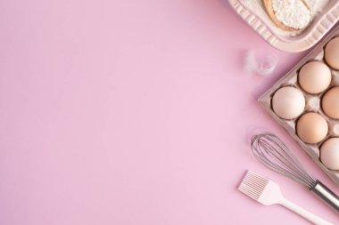 Hafif pembe pastel arka planda yemek pişirmek için gerekli malzemelerin çerçevesi. Fotokopi alanı olan düz bir yemek pişirme. Üst Manzara. Pişirme konsepti. düz yat