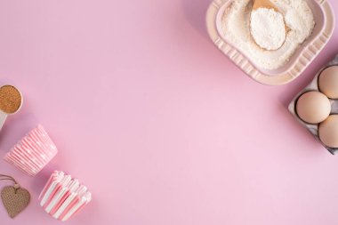 Hafif pembe pastel arka planda yemek pişirmek için gerekli malzemelerin çerçevesi. Fotokopi alanı olan düz bir yemek pişirme. Üst Manzara. Pişirme konsepti. düz yat