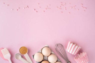 Hafif pembe pastel arka planda yemek pişirmek için gerekli malzemelerin çerçevesi. Fotokopi alanı olan düz bir yemek pişirme. Üst Manzara. Pişirme konsepti. düz yat