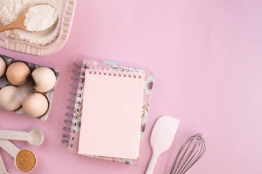 Hafif pembe pastel arka planda yemek pişirmek için gerekli malzemelerin çerçevesi. Fotokopi alanı olan düz bir yemek pişirme. Üst Manzara. Pişirme konsepti. düz yat