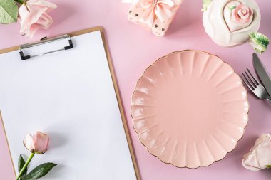 Açık pembe arka planda pembe güller ve hediye kutularıyla birlikte metin için yer açılmış pano modeli. Kutlama kompozisyonu. Uzayı kopyala Üst Manzara. Düz yatıyordu.