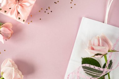 Pembe arka planda bir gül olan şenlik afişi. Üst manzara, düz yatış. Uzayı kopyala Doğum günü, anneler, sevgililer günü, kadınlar, düğün günü konsepti.