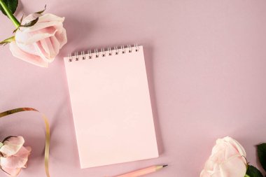 Açık pembe arkaplan ve pembe güller üzerine yazdığın metin için uzay not defterini kopyala. düz yatış, Üst Görünüm