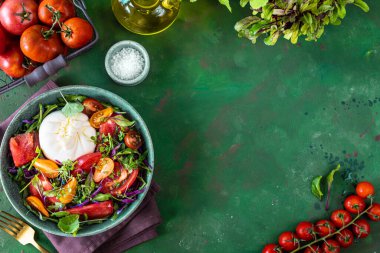 Domatesli salata, roka, yeşil taştan arka planda Burrata peyniri ve mikroyeşillikler. Boşluğu kopyala