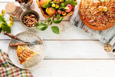 Beyaz ahşap arka planda ev yapımı elmalı turta ve malzemeler. Üst görünüm