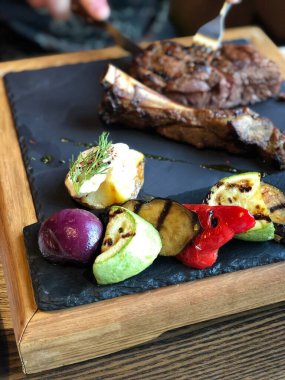 Karanlık tahtada haşlanmış sebzeler, bulanık arka plan.