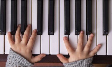 Piyano şarkıları söyleyen küçük bir kız.