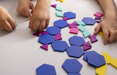 Evde tahta tuğlalarla modellik yapan çocuklar.