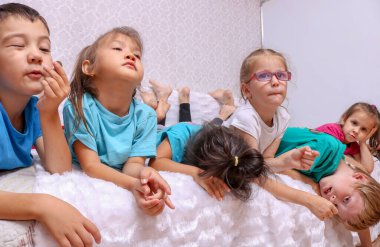 Çocuklar kanepede yatıyor, çocuklar birlikte eğleniyor.