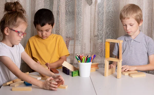Tři Děti Hrají Dřevěnými Kostkami Stole — Stock fotografie