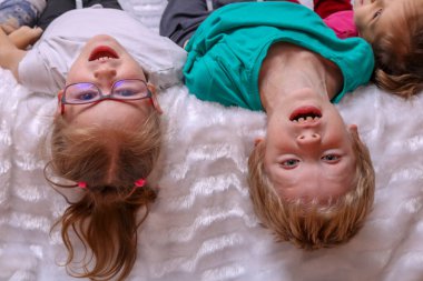 Kardeşler kanepede uzanıp kameraya bakıyorlar.