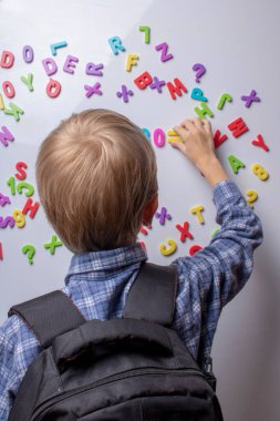 boy with full backpack counting numbers