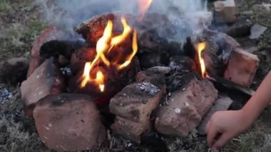 Birisi kömürde patates pişiriyor.