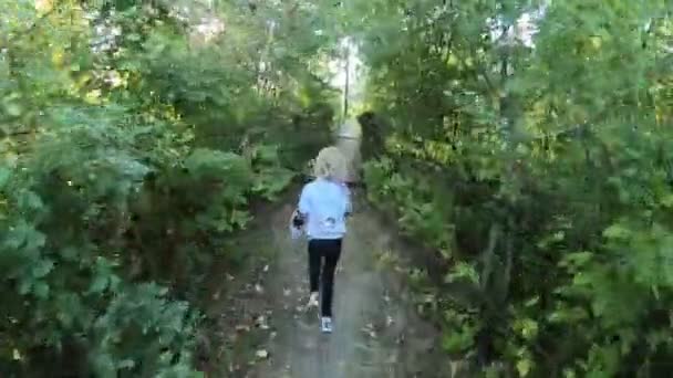 那孩子沿着小路跑着 走到河上挂着的木桥上 — 图库视频影像