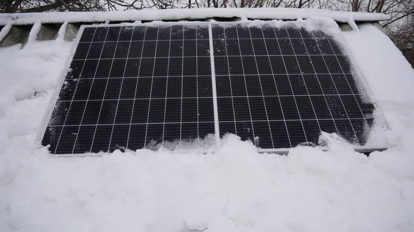 雪覆在太阳能电池板上 在降水过程中 太阳能电池产生的能量较少 免版税图库照片