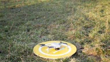 Dron kuadkopteri sarı platformdan başlıyor. Başlamadan önce motoru açar ve kontrol eder. Kalkış için Glade.