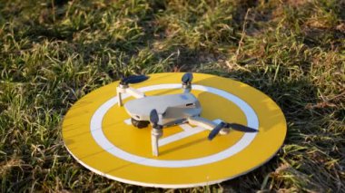  Dron kuadkopteri sarı platformdan başlıyor. Başlamadan önce motoru çalıştırır ve kontrol eder..