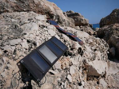 Bir güneş paneli kumlu bir çölde akıllı telefona şarj oluyor. 