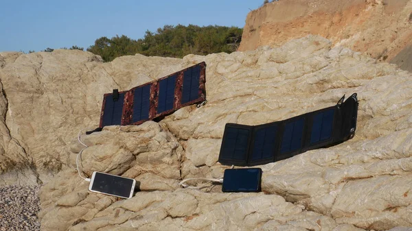 Panele Słoneczne Ładują Smartfony Skałach Pobliżu Morza — Zdjęcie stockowe