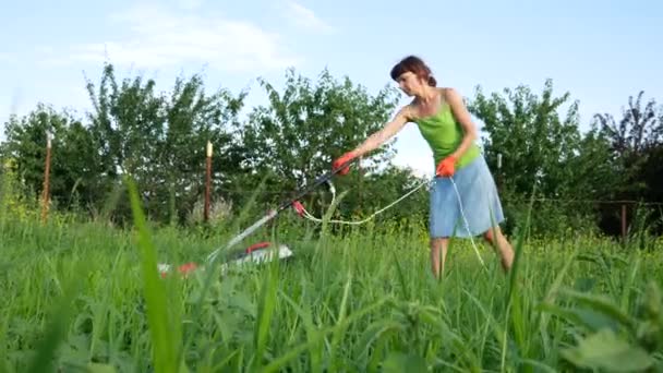 Dziewczyna Kosi Trawę Kosiarką Elektryczną — Wideo stockowe