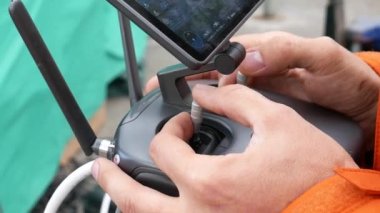 İnsansız hava aracının uzaktan kumandası. Adam kolları eğiyor ve dronu kontrol ediyor..