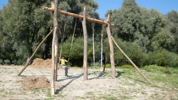 Girl Rides Large Wooden Swing Clear Sunny Day Bank River — Stock Video