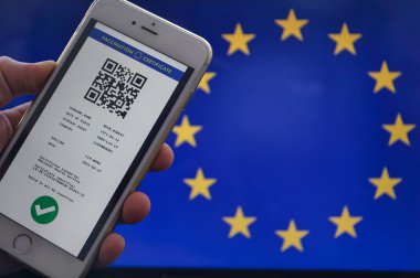 Avrupa Birliği 'nin QR kodlu dijital yeşil sertifikası havaalanında bir el tarafından tutulan bir cep telefonunun ekranında. Aşılama pasaport kavramı