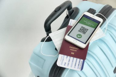 Gezgin, Coronavirus Covid-19 aşısı olduğunu onaylamak için havaalanındaki cep telefonunda aşı sertifikası gösteriyor. Dokunulmazlık kavramı