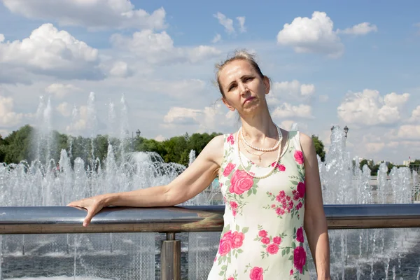 Mujer de pie cerca de la fuente — Foto de Stock