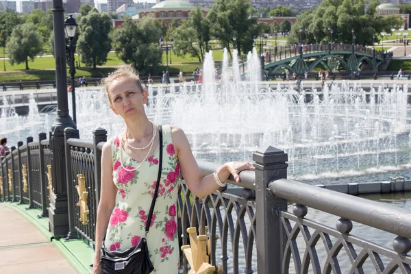 Mujer de pie cerca de la fuente — Foto de Stock