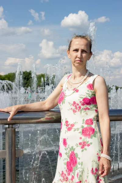 Mujer de pie cerca de la fuente — Foto de Stock