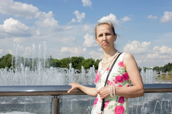 Mujer de pie cerca de la fuente — Foto de Stock