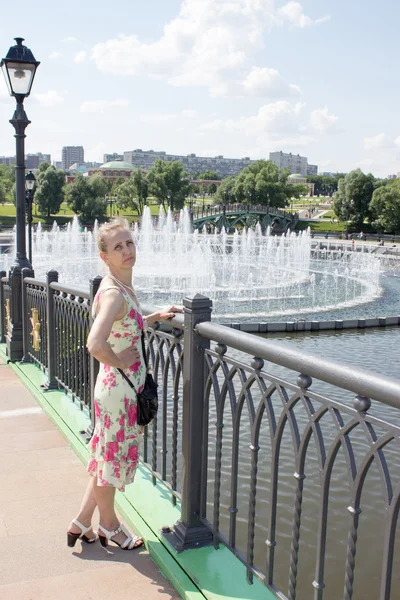 Kobieta stojąc przy fontannie — Zdjęcie stockowe