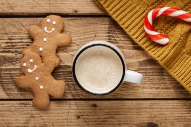 Noel bastonlu sıcak kakao ve ahşap arka planda zencefilli adam.